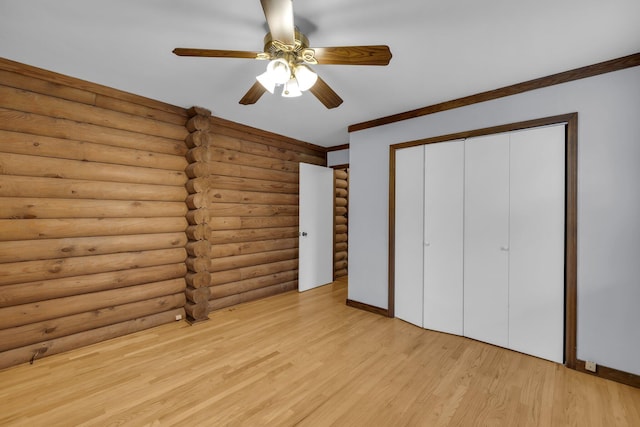 unfurnished bedroom featuring rustic walls, light hardwood / wood-style flooring, ornamental molding, a closet, and ceiling fan