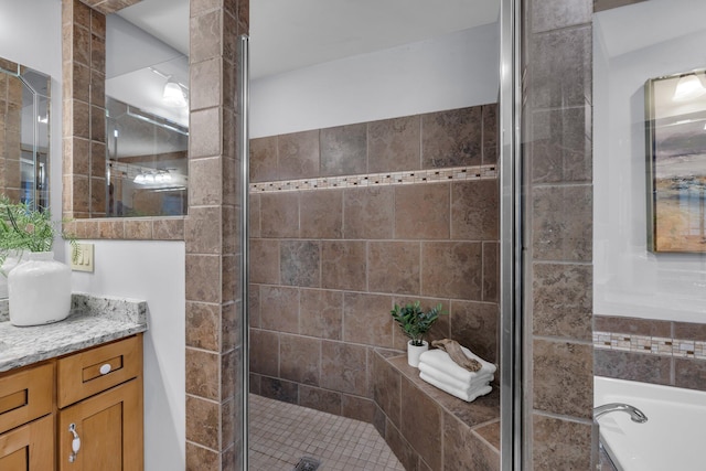 bathroom featuring vanity and independent shower and bath