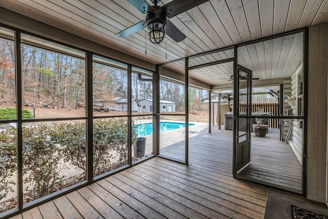 unfurnished sunroom with wood ceiling and ceiling fan