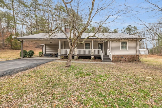 ranch-style home featuring a front lawn, a carport, and covered porch