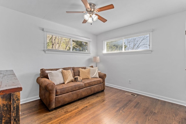 living room featuring dark hardwood / wood-style floors and ceiling fan