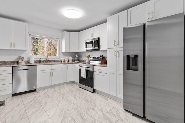 kitchen with white cabinetry, light stone countertops, and appliances with stainless steel finishes