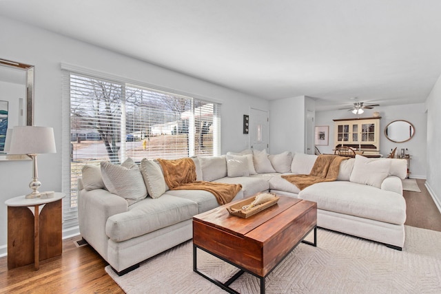 living room featuring hardwood / wood-style floors and ceiling fan