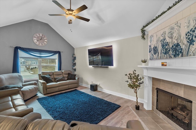 living room featuring a fireplace, light hardwood / wood-style floors, vaulted ceiling, and ceiling fan