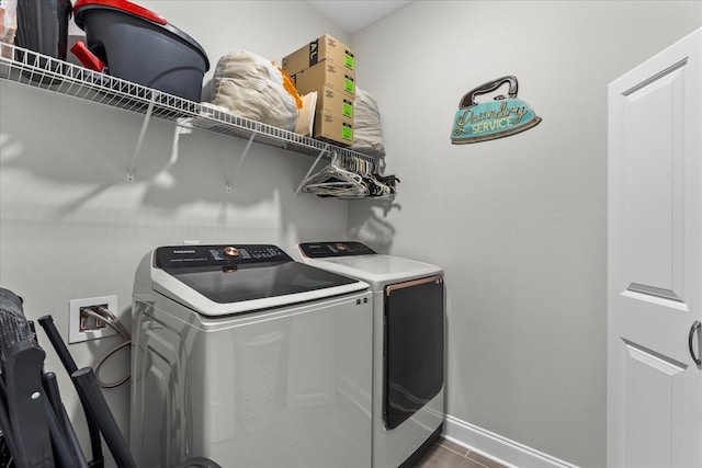 laundry area featuring tile patterned floors and washing machine and clothes dryer