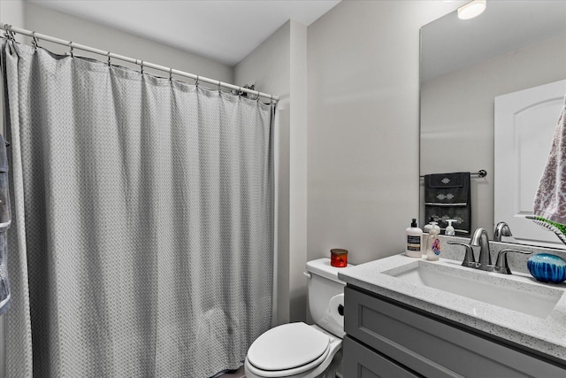 bathroom featuring toilet, a shower with shower curtain, and vanity