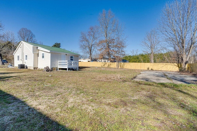 view of yard with a wooden deck and central air condition unit