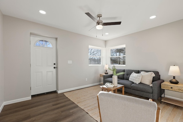 living room with dark wood-type flooring and ceiling fan