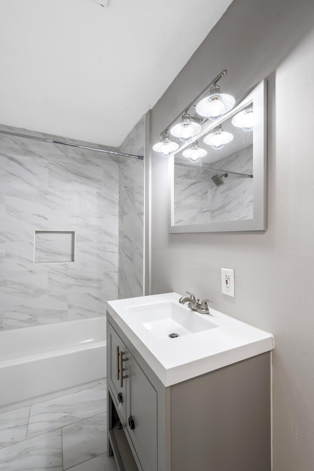 bathroom with vanity and tiled shower / bath