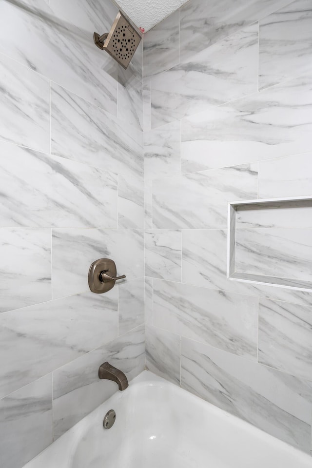 bathroom with tiled shower / bath combo