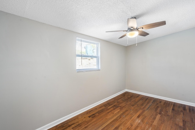 empty room with ceiling fan, dark wood-type flooring, and a textured ceiling