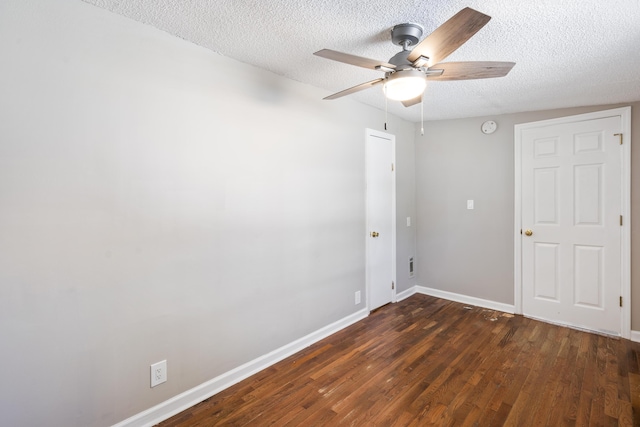 spare room with a textured ceiling, ceiling fan, and dark hardwood / wood-style flooring