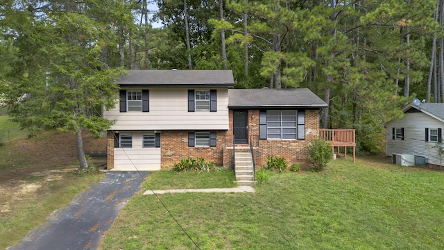 tri-level home featuring a garage and a front lawn