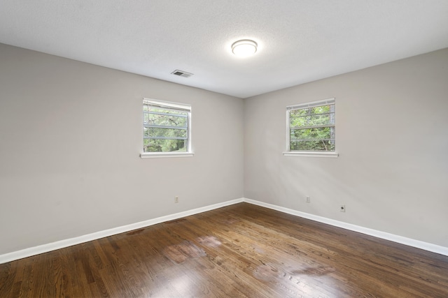 unfurnished room with hardwood / wood-style flooring, a wealth of natural light, and a textured ceiling