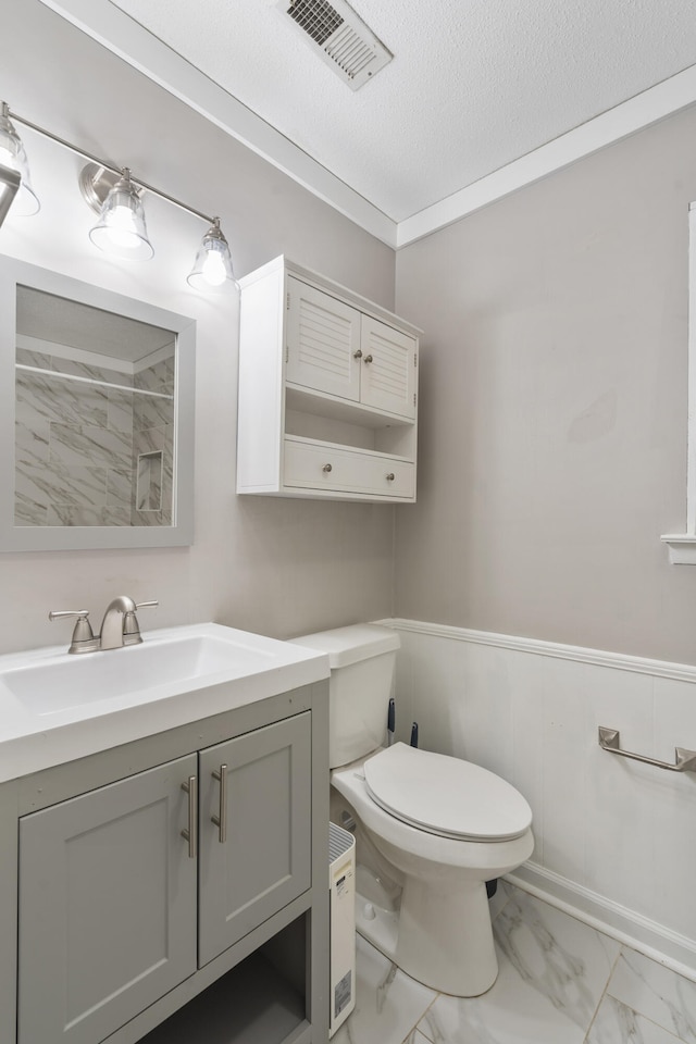 bathroom with crown molding, toilet, a textured ceiling, and vanity