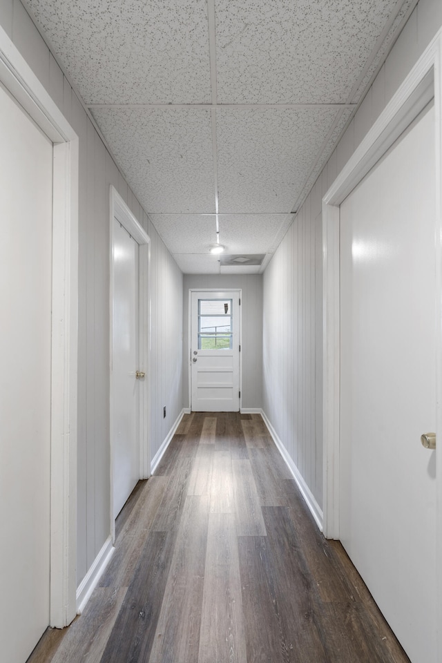 hall featuring a paneled ceiling and dark hardwood / wood-style floors