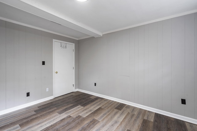 spare room featuring wood-type flooring, wood walls, and crown molding