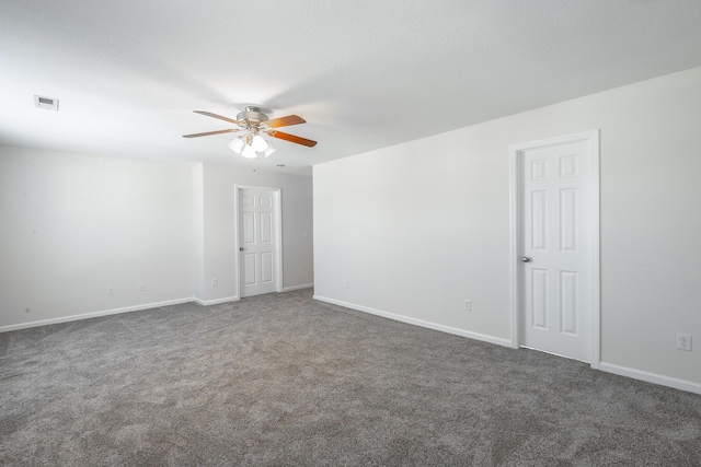 unfurnished room featuring ceiling fan and dark colored carpet