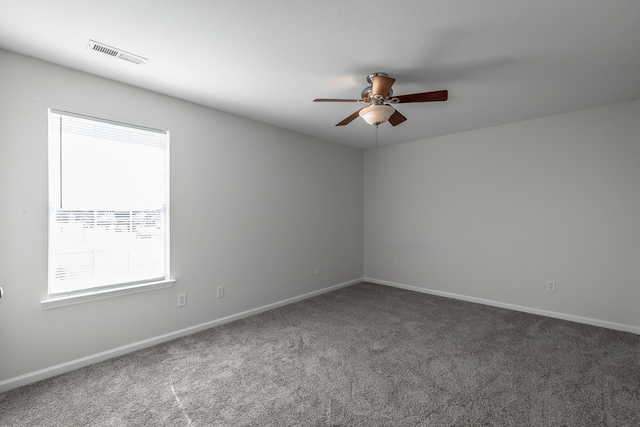 carpeted empty room with ceiling fan and plenty of natural light