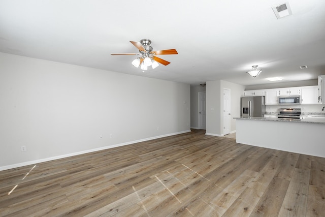 unfurnished living room featuring ceiling fan and light wood-type flooring