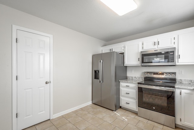 kitchen featuring light tile patterned floors, stainless steel appliances, white cabinets, and light stone countertops