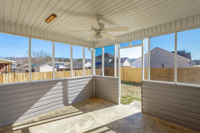 unfurnished sunroom with ceiling fan