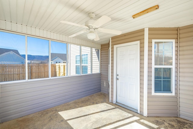 unfurnished sunroom with ceiling fan