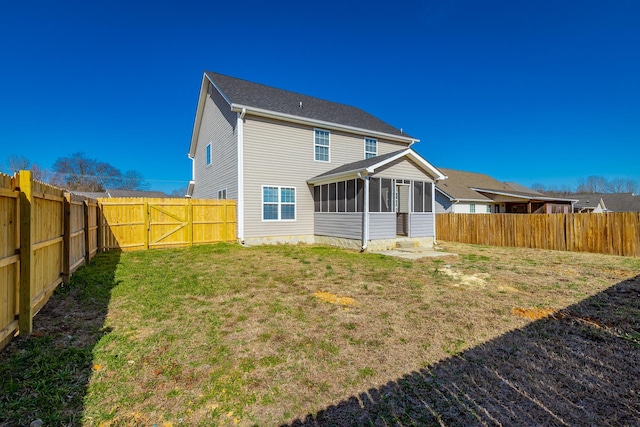 back of house featuring a lawn and a sunroom