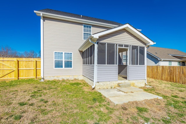 rear view of house featuring a sunroom and a yard