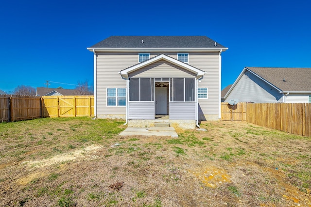 back of property with a sunroom and a yard