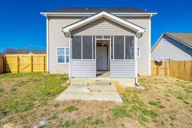 rear view of house with a yard and a sunroom