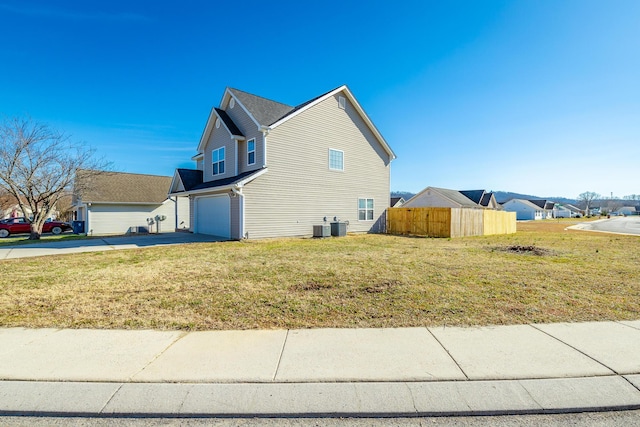 view of property exterior with a garage, a yard, and central air condition unit