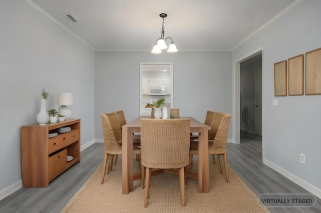 dining area with an inviting chandelier, ornamental molding, and light hardwood / wood-style flooring