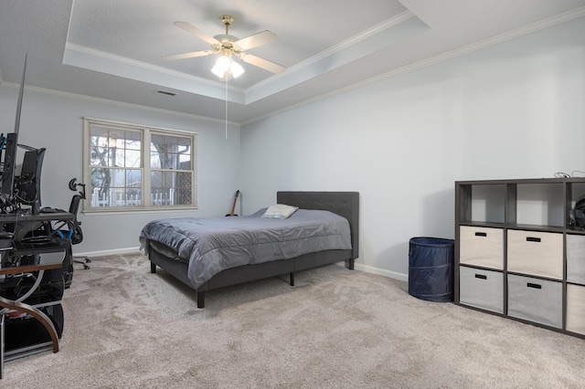 carpeted bedroom with crown molding, ceiling fan, and a tray ceiling