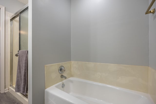 bathroom featuring a tub and a textured ceiling