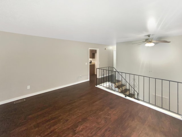 empty room with dark wood-type flooring and ceiling fan