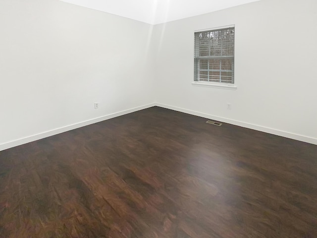 unfurnished room featuring dark wood-type flooring