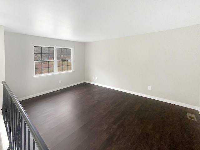 spare room with dark hardwood / wood-style flooring