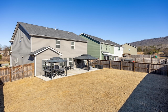 back of property with a mountain view, a gazebo, a yard, and a patio