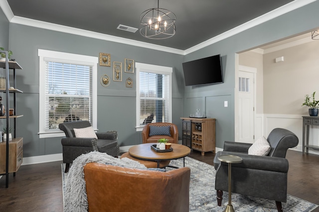 living room with crown molding, dark hardwood / wood-style floors, and an inviting chandelier