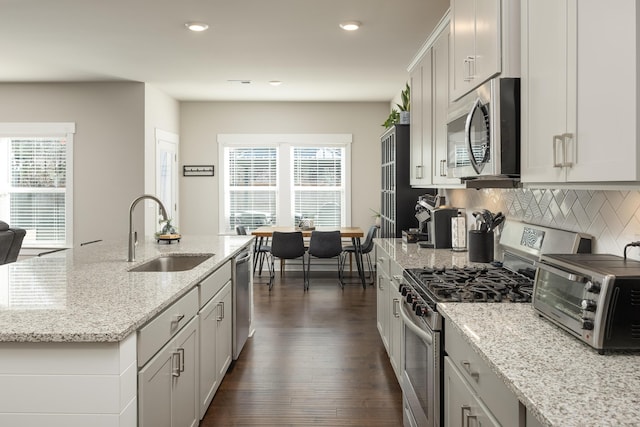 kitchen featuring sink, stainless steel appliances, light stone countertops, and backsplash