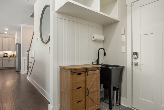 interior space featuring stainless steel fridge, dark hardwood / wood-style flooring, and ornamental molding