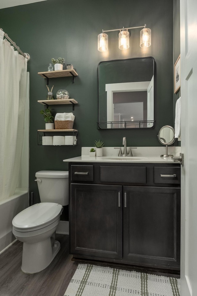 full bathroom featuring vanity, hardwood / wood-style flooring, shower / bath combo with shower curtain, and toilet