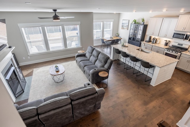 living room featuring sink, dark hardwood / wood-style floors, and ceiling fan