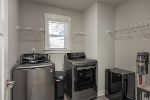 clothes washing area featuring hardwood / wood-style flooring and separate washer and dryer