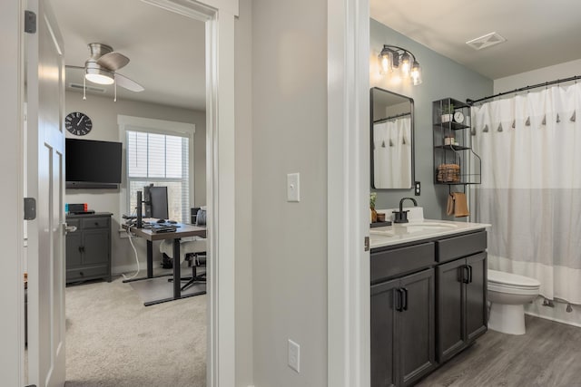 bathroom with ceiling fan, curtained shower, toilet, and vanity