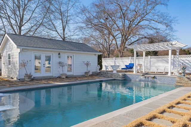 view of swimming pool featuring an outbuilding, a pergola, pool water feature, and french doors