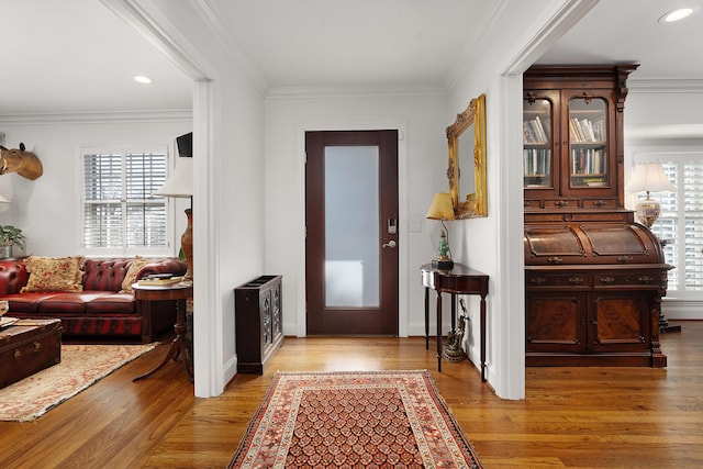 foyer with crown molding and light wood-type flooring