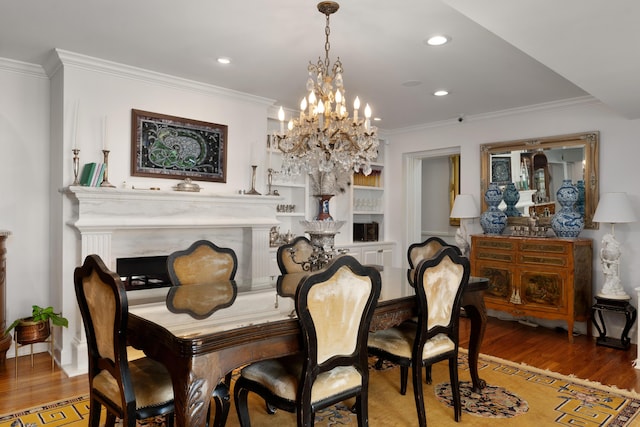 dining space featuring built in shelves, wood-type flooring, and crown molding