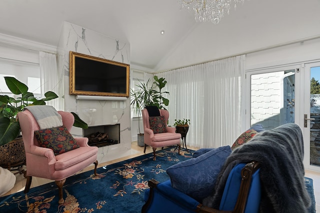 living room featuring an inviting chandelier, hardwood / wood-style floors, high vaulted ceiling, a fireplace, and ornamental molding